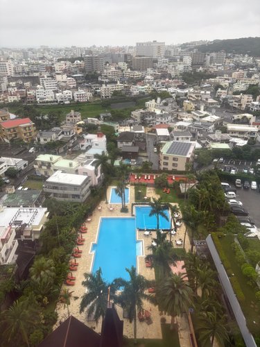 客室の窓から見下ろしたプールと那覇の街並み